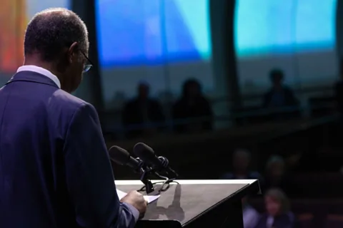 Ben Carson reading from the Bible at the lectern.