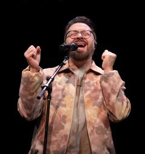A participant reading or leading worship at America Reads the Bible.